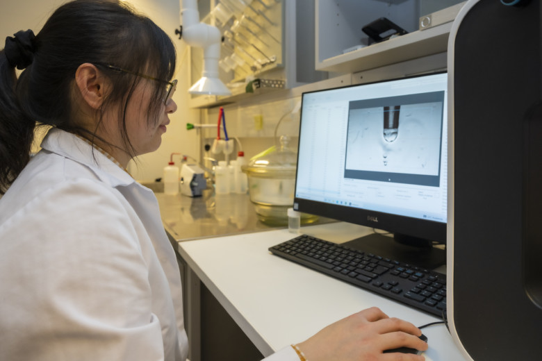 Researcher Ya Zhu using a machine to test the water-resistance qualities of a film.